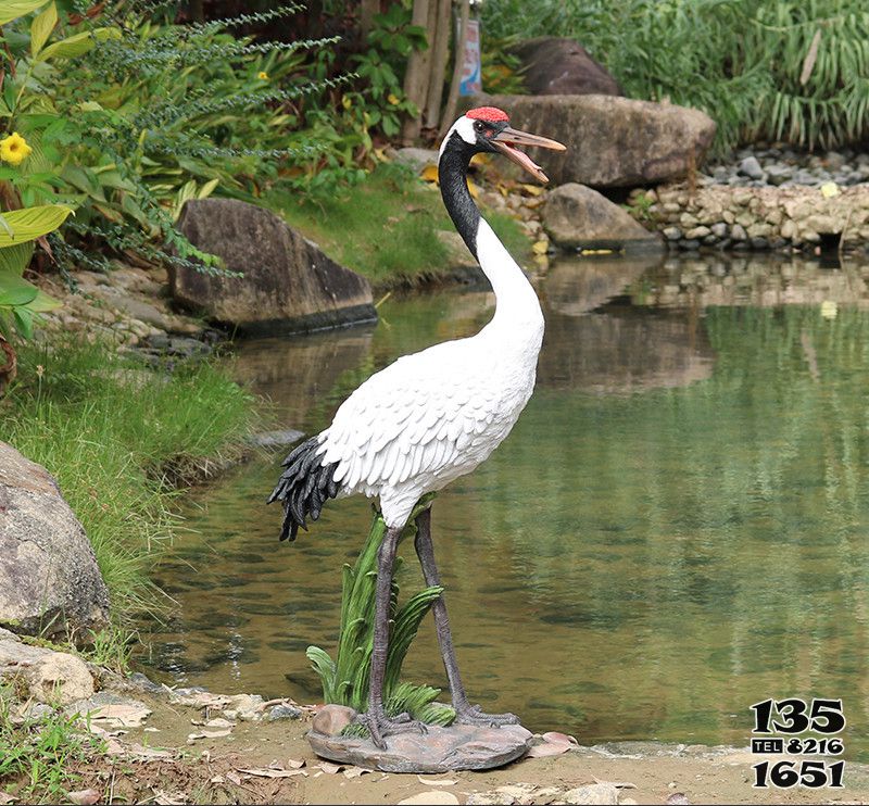 仙鶴雕塑-景區(qū)池塘一只捕魚(yú)覓食的玻璃鋼仙鶴雕塑高清圖片